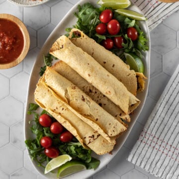 6 large taquitos stacked on a platter