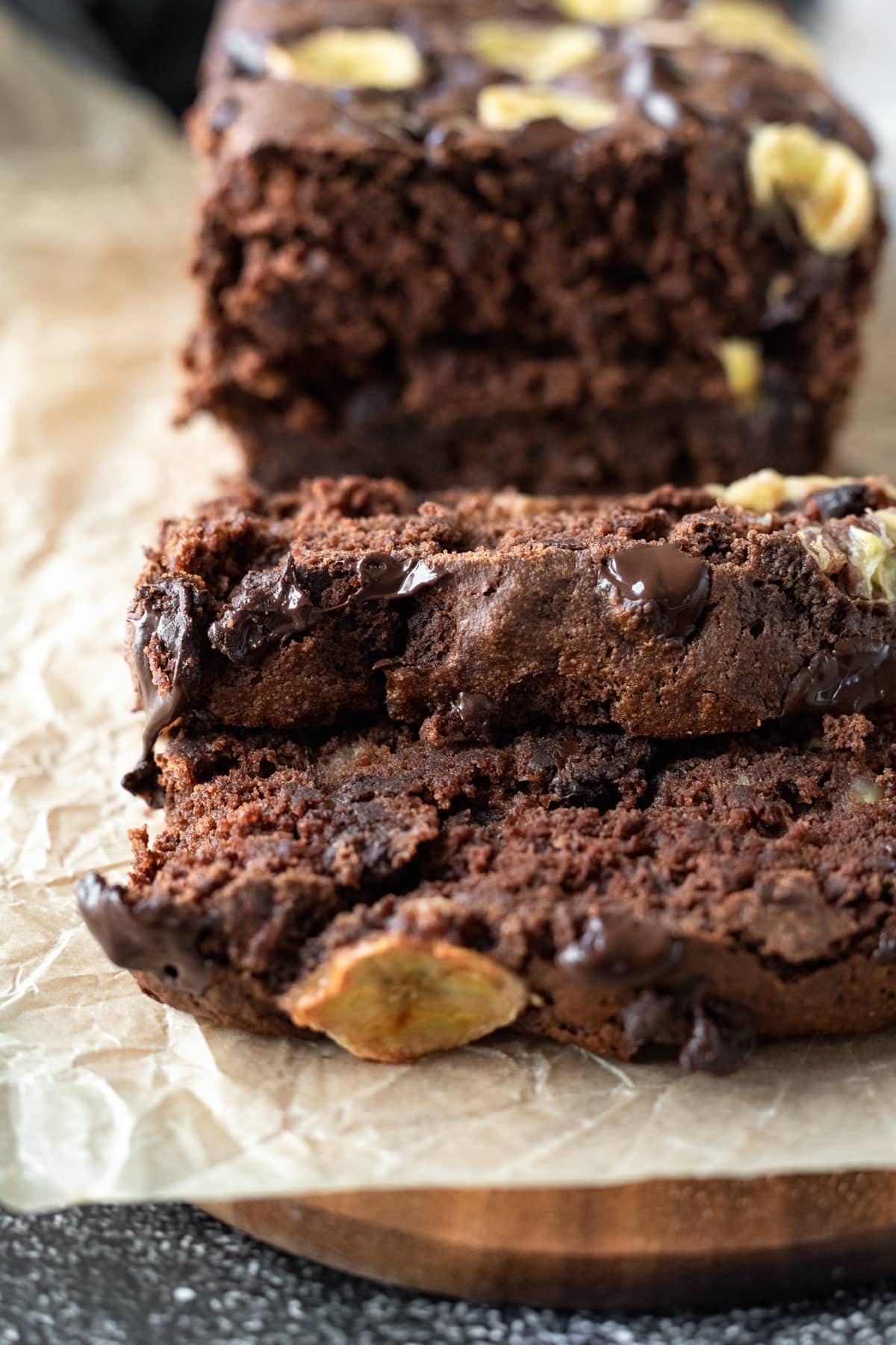 close up of slices of rich chocolate banana bread on a cutting board.