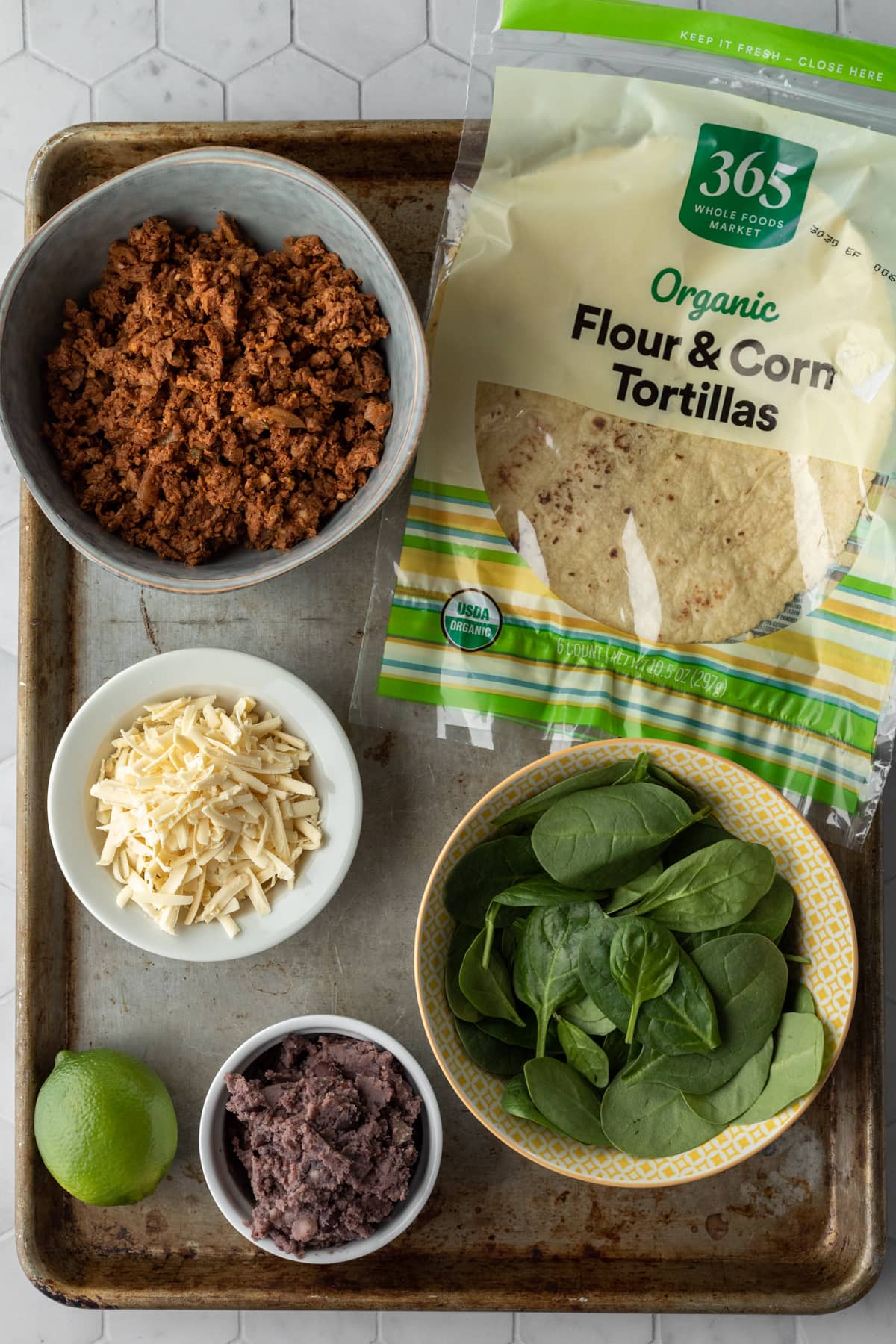 Ingredients for vegan taquitos laid out on a large pan.