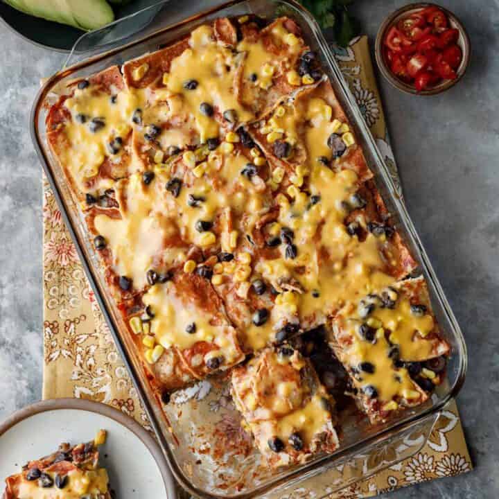 Overhead shot of vegan enchilada casserole in a glass baking dish.