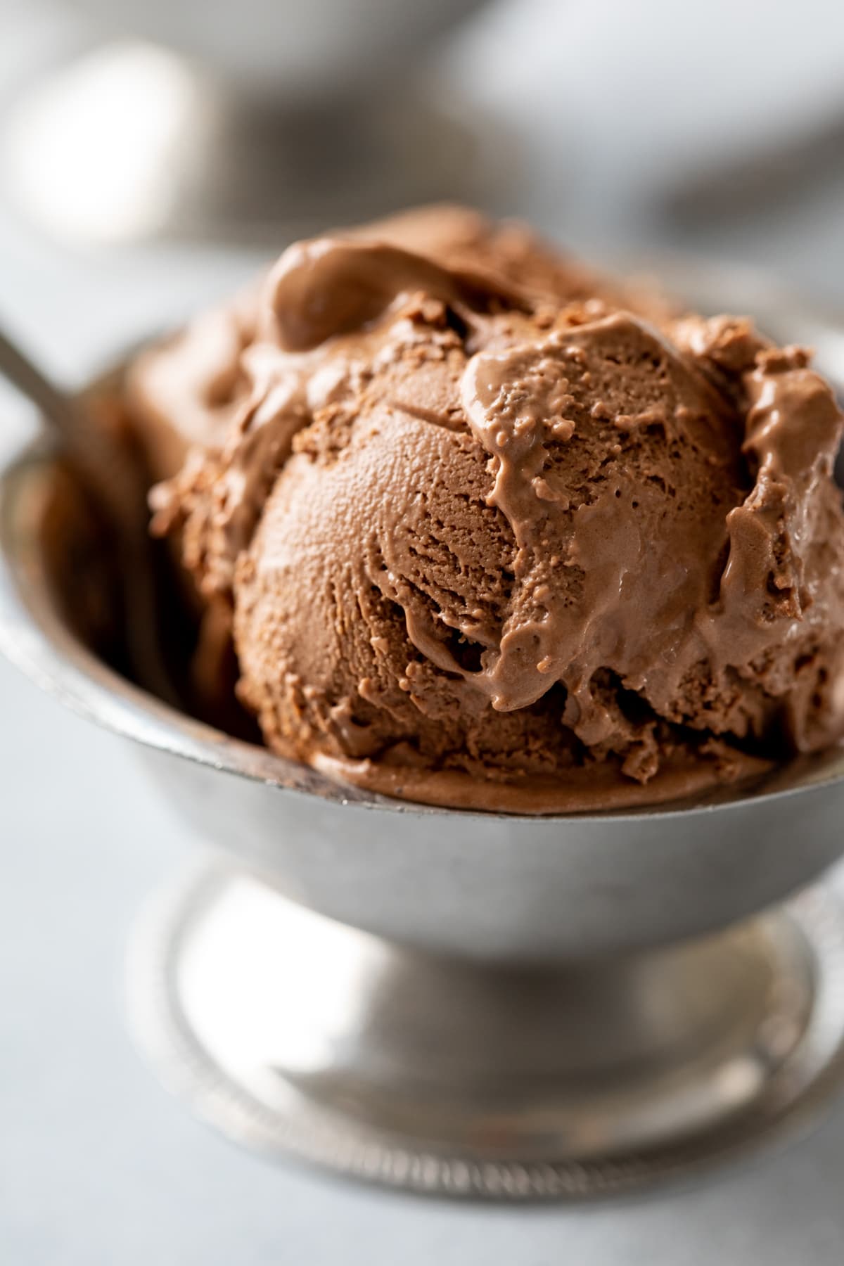 close up of 2 scoops of creamy dairy-free ice chocolate cream in a silver bowl.