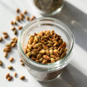 close up showing color and texture of roasted pepitas in a jar.