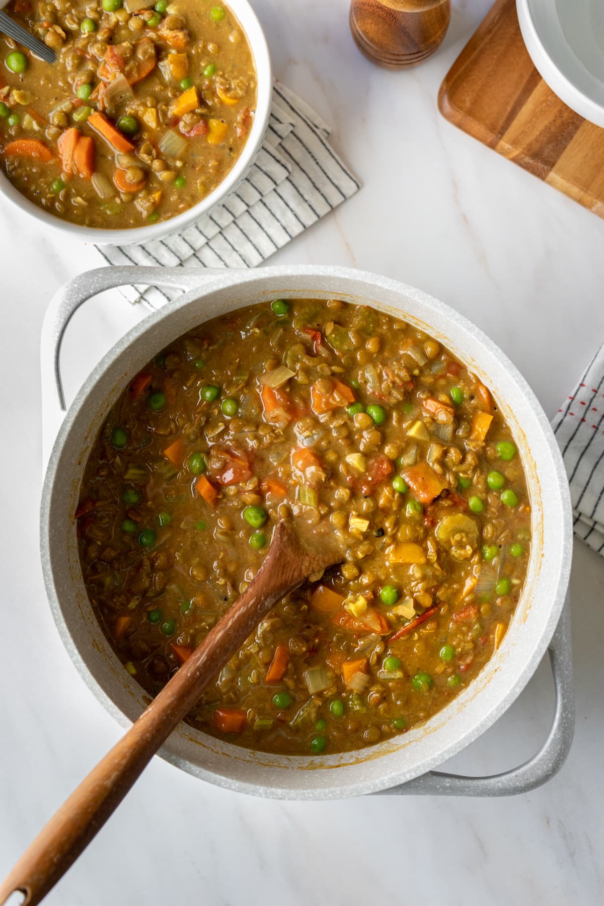 serving lentil soup from a large pot