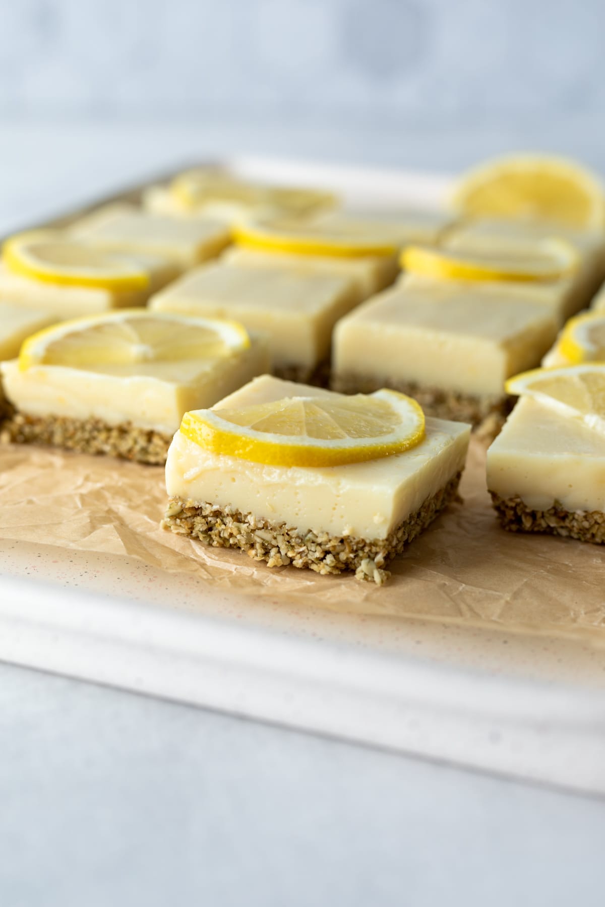 side view of healthy lemon bars on parchment paper.