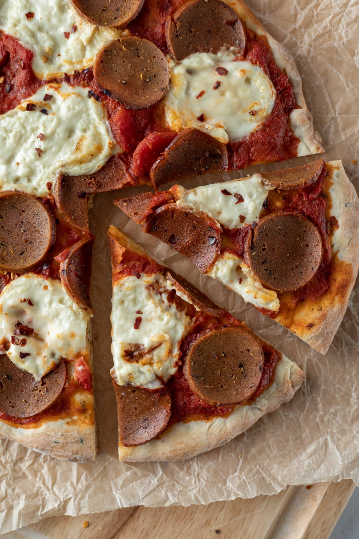 homemade vegetarian pepperoni pizza on a cutting board.