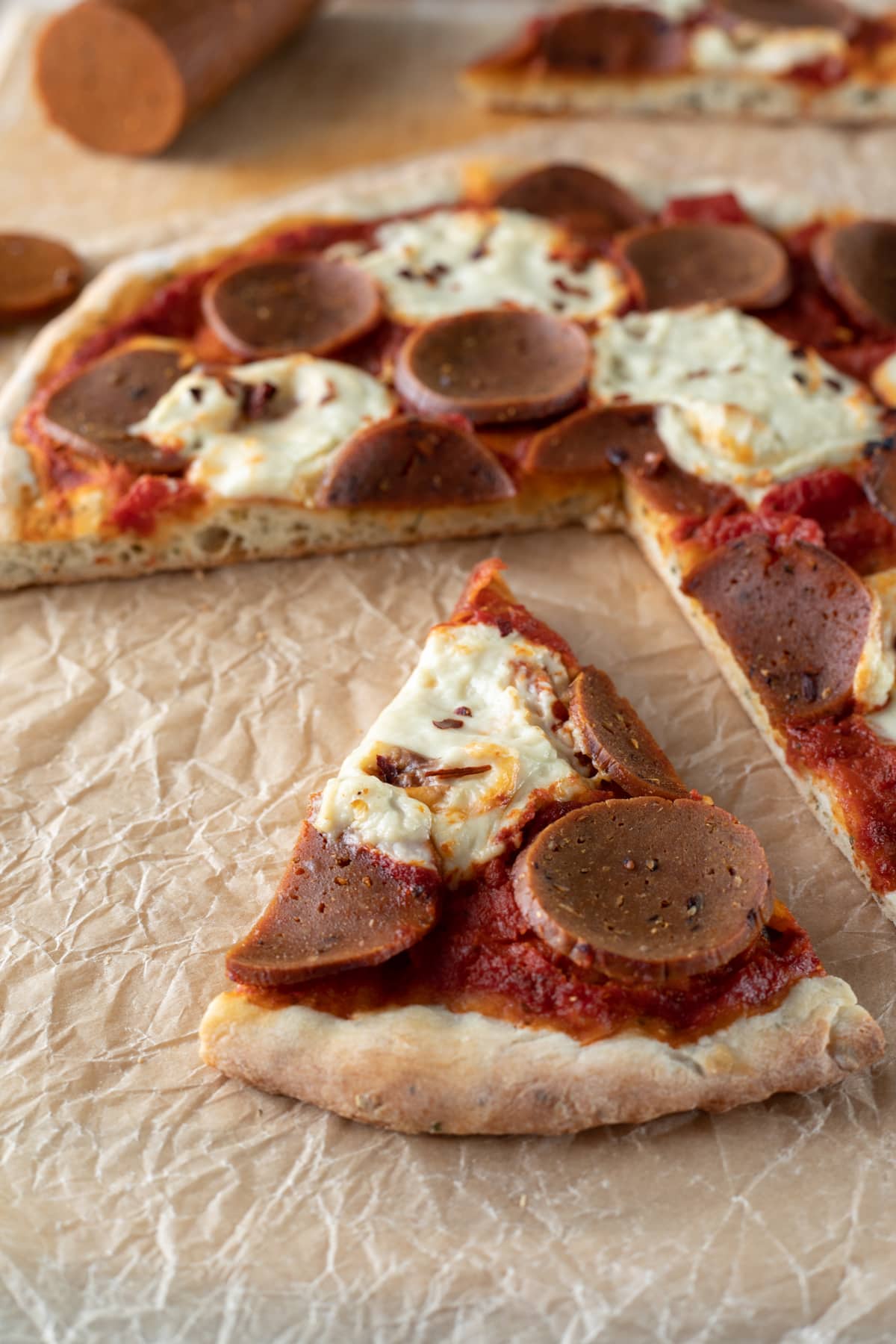 a photo of sliced homemade vegan pepperoni pizza.