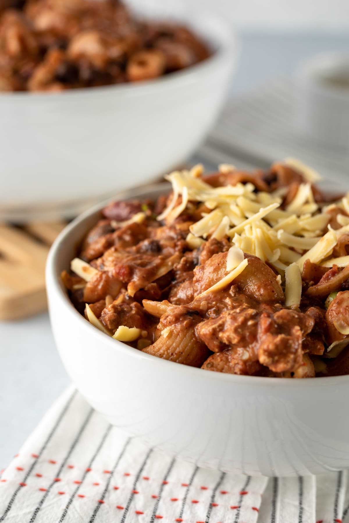 close up of chunky and meaty vegetarian chili mac in a white bowl.