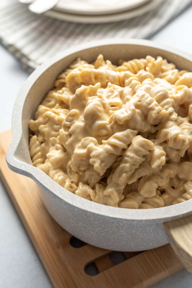 backlit photo of super creamy looking mac and cheese in a pot.