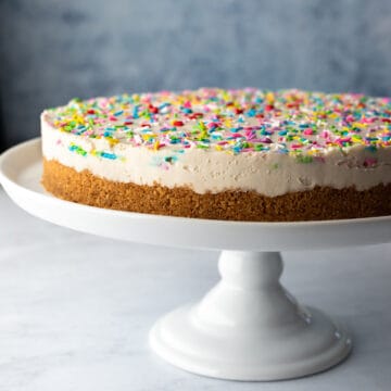 whole cheesecake resting on a white cake stand
