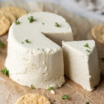 wedge slice cut from wheel of vegan cheese