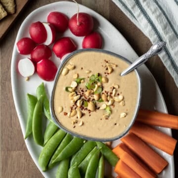 peanut white bean dip on a platter with vegetables.