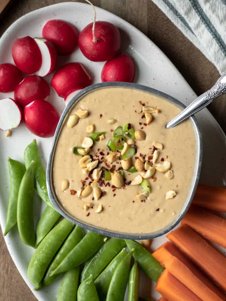 peanut white bean dip on a platter with vegetables.
