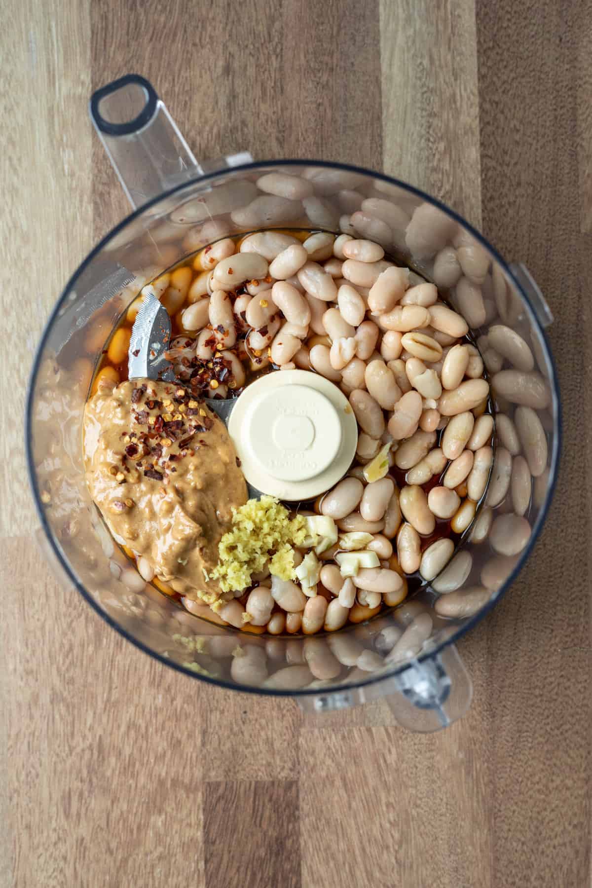 ingredients inside the bowl of a food processor before blending.