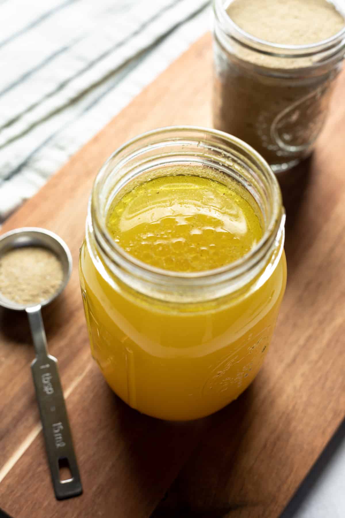 jar filled with prepared vegan chicken broth with the dry seasoning powder on the side.