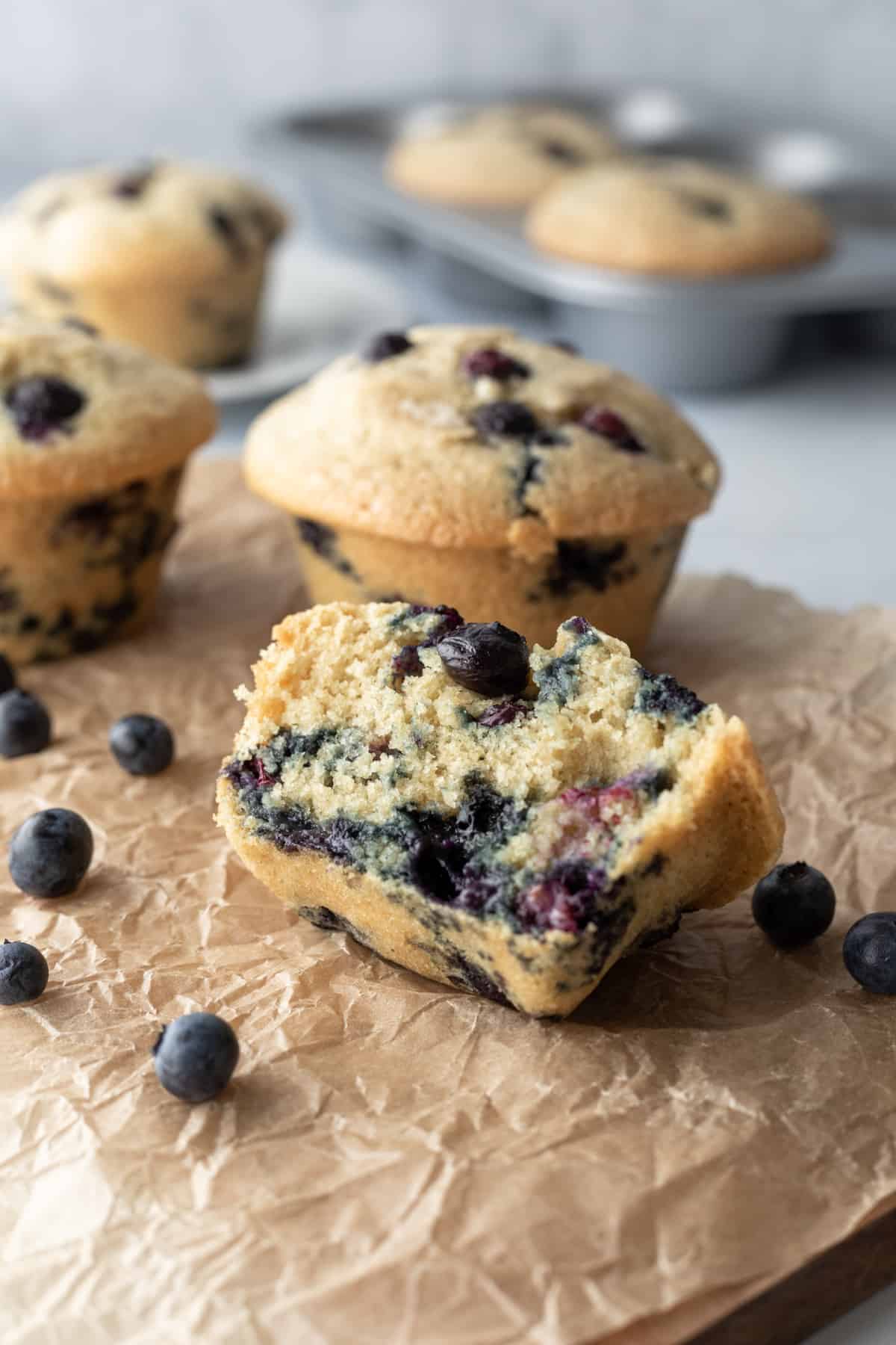 muffin cut in half showing moist, fluffy crumb and juicy berries inside.