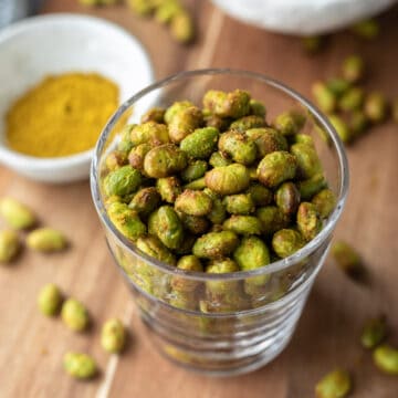 looking down at crispy roasted edamame in a glass.