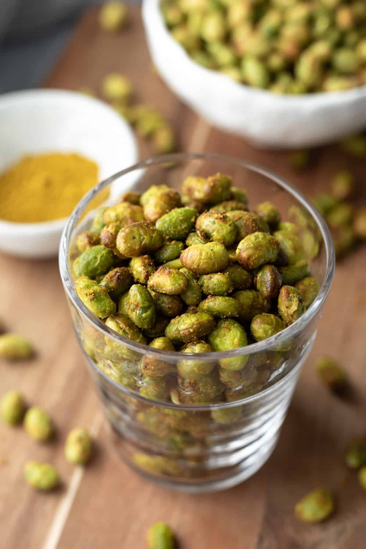 close up of crispy edamame in a glass.