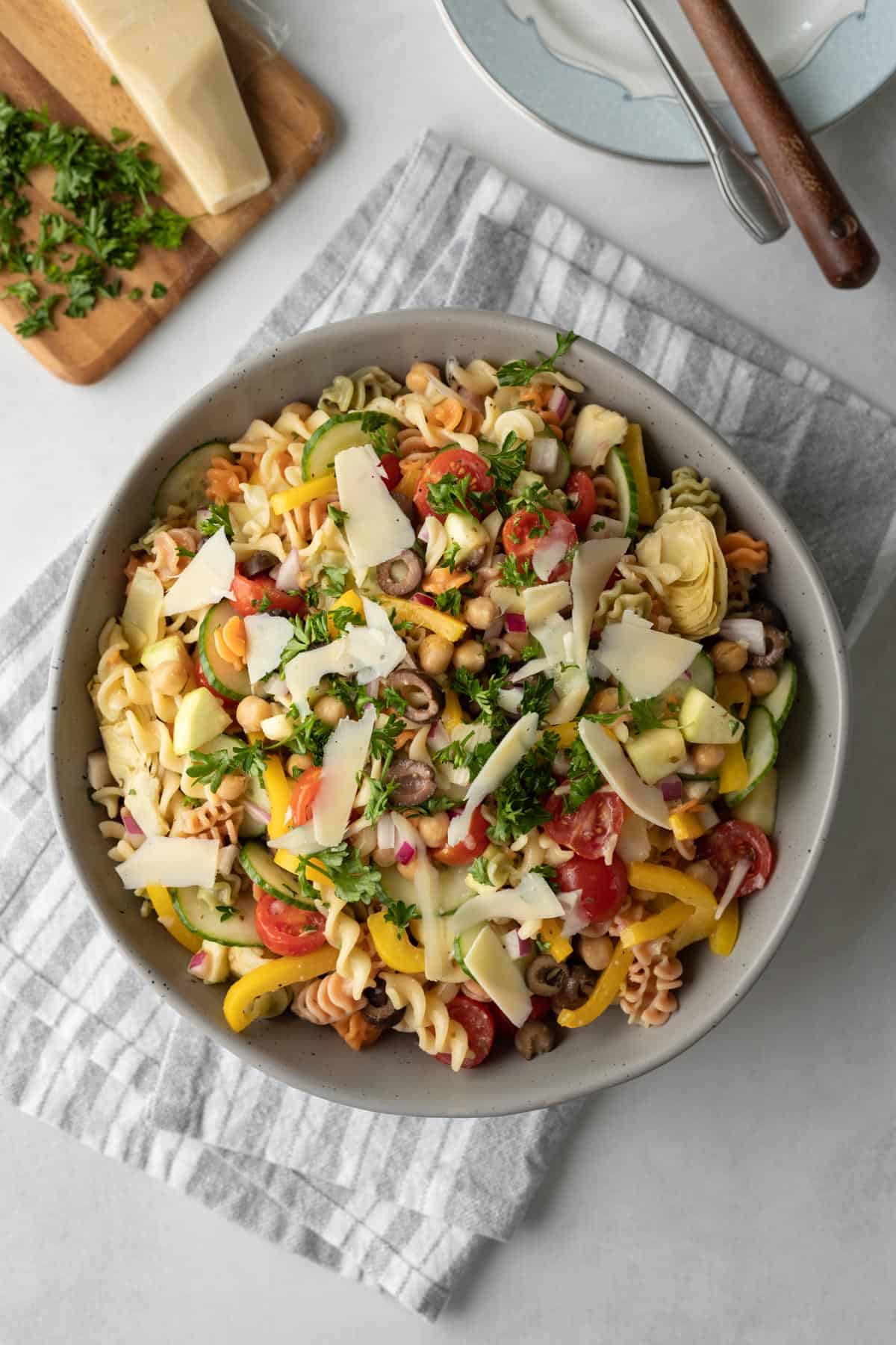 overhead view of vegan pasta salad in a serving bowl on a gray striped napkin.