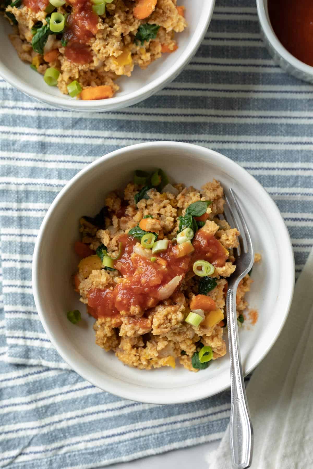 serving of creamy millet with vegetables and soy curls in a bowl.