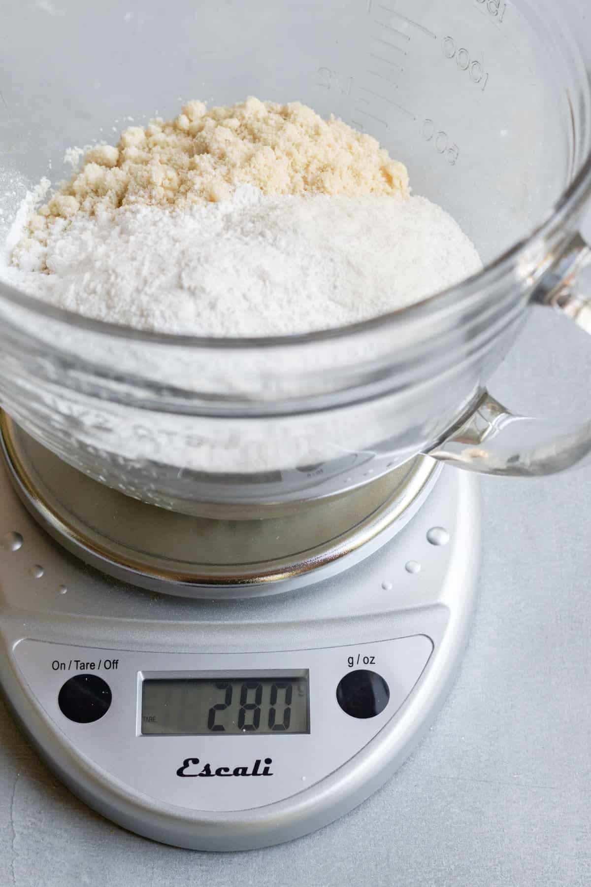 using a small kitchen scale to weigh flours.