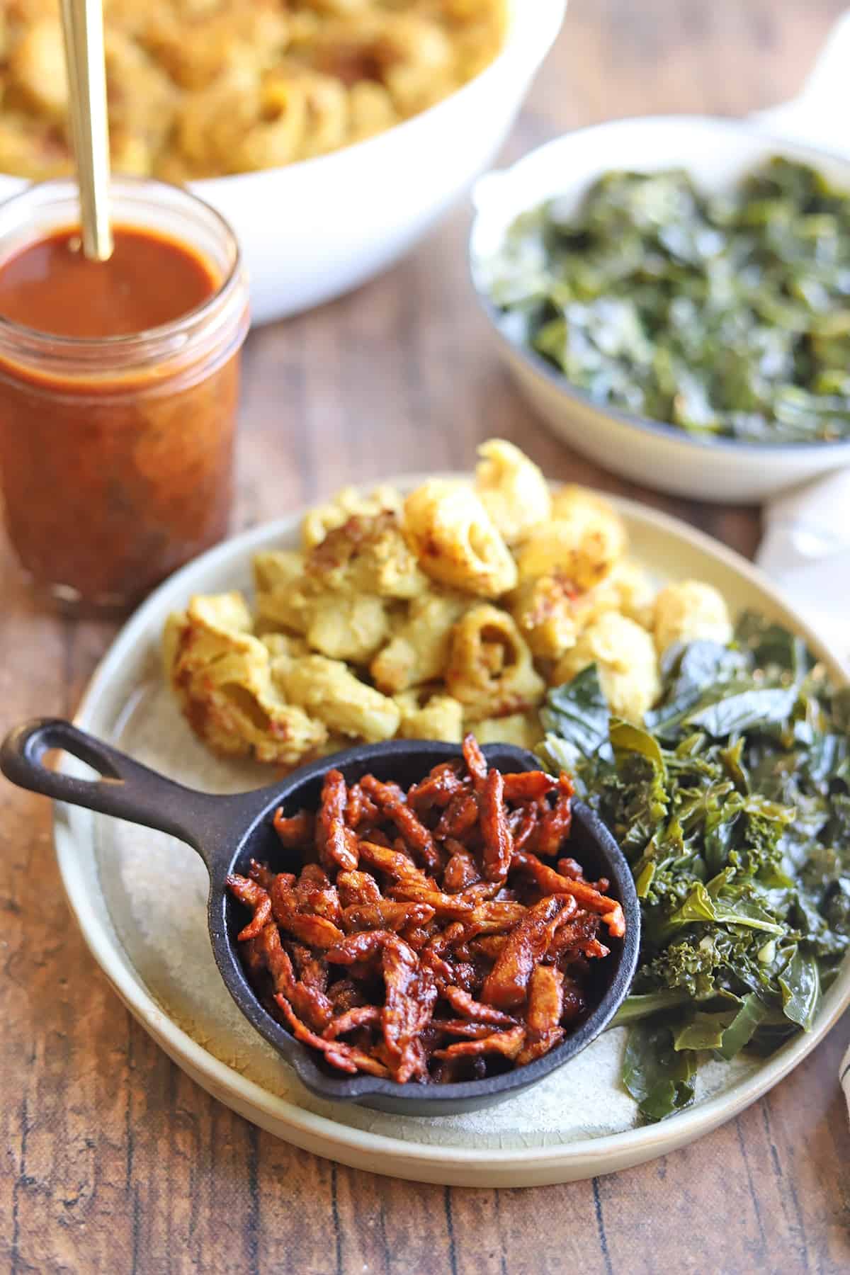 plate with greens, mac and cheese, and vegan pulled pork.