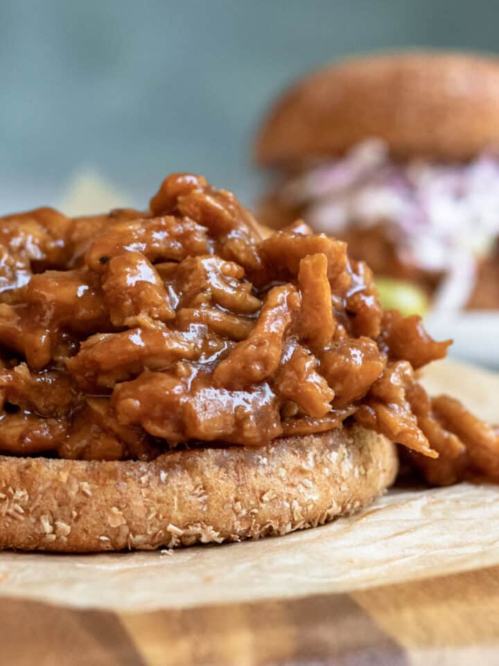 close up side view of BBQ soy curls on a bun.