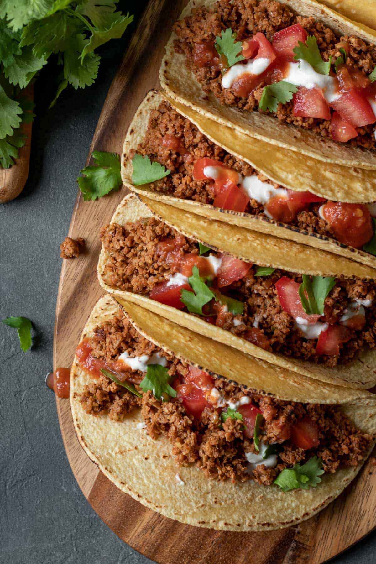 soy curl tacos lined up on a wood board.