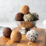 raw vegan energy balls with different coatings stacked in a silver bowl.