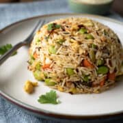 serving of fried rice with vegetables on a plate.