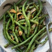 close up overhead view of air fried green beans in a bowl.