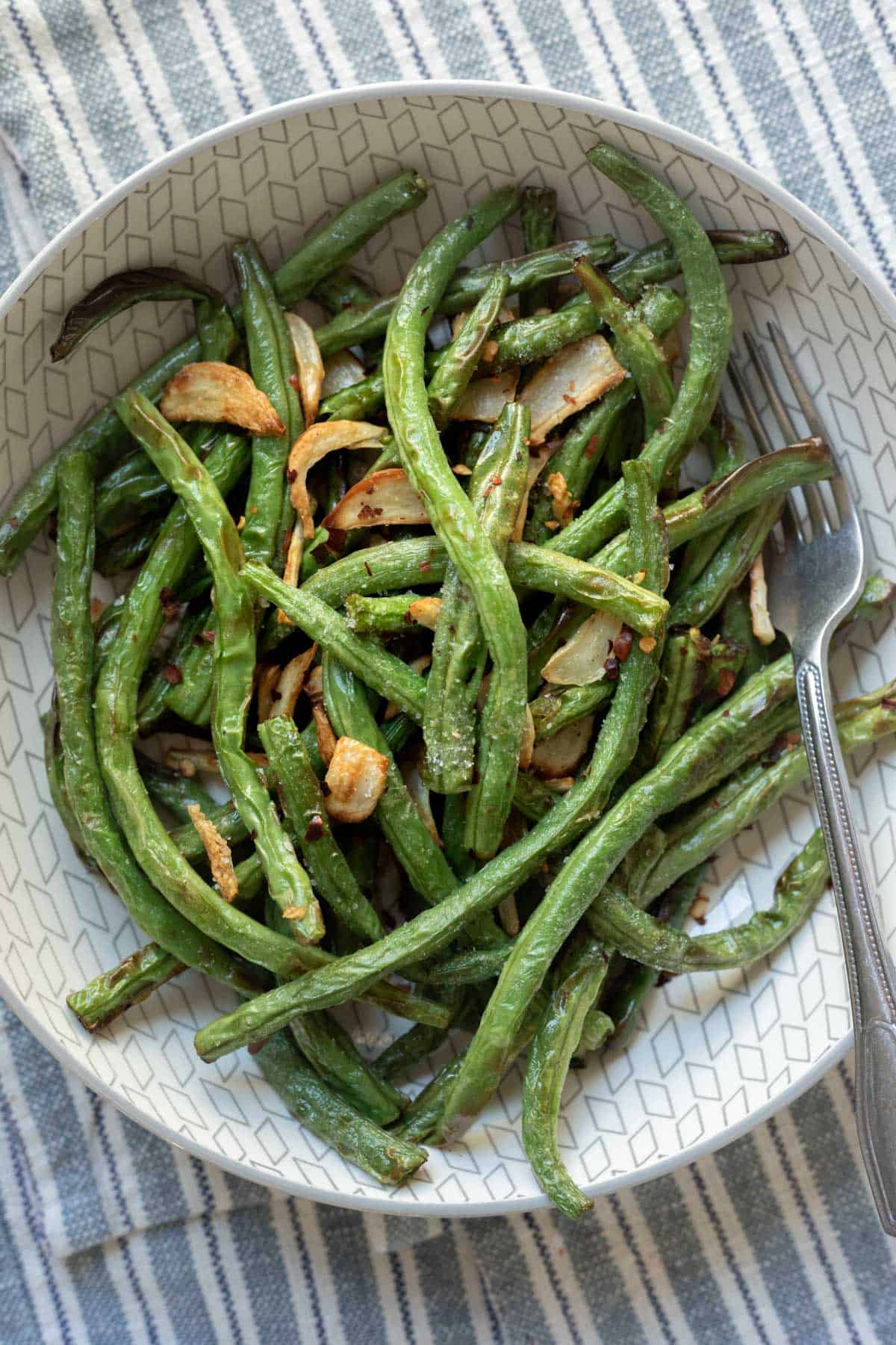 air fried green beans with crispy garlic in a serving bowl.