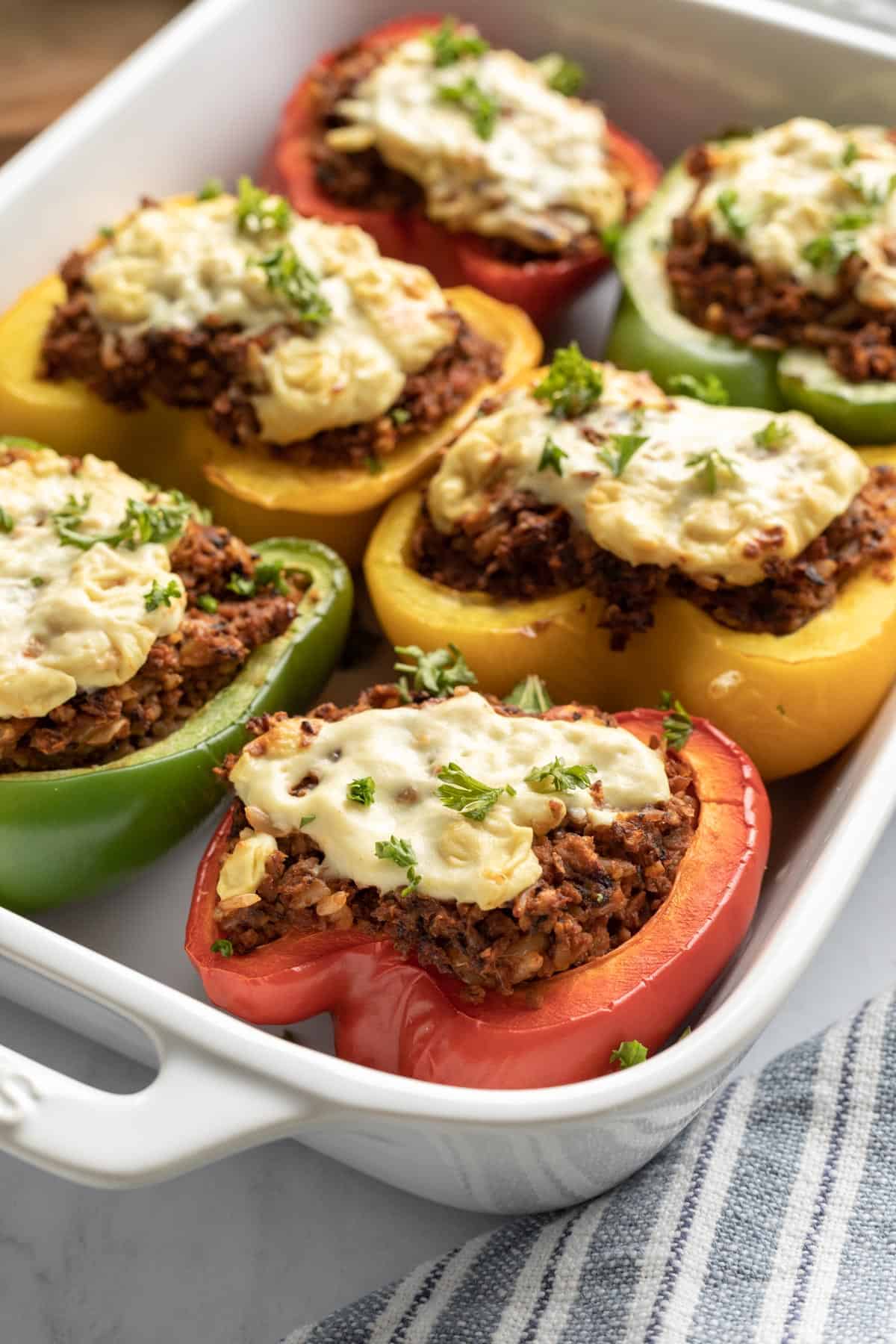 colorful vegan stuffed peppers served in a white dish.
