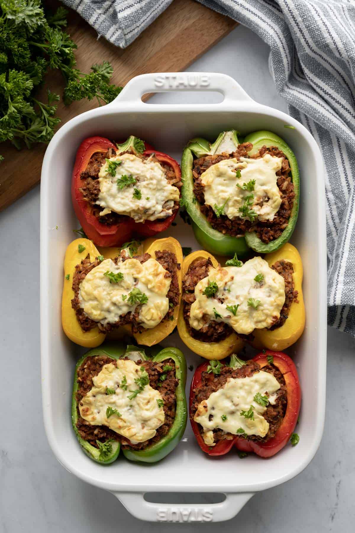 overhead photo of six stuffed peppers topped with melted cheese and parsley.