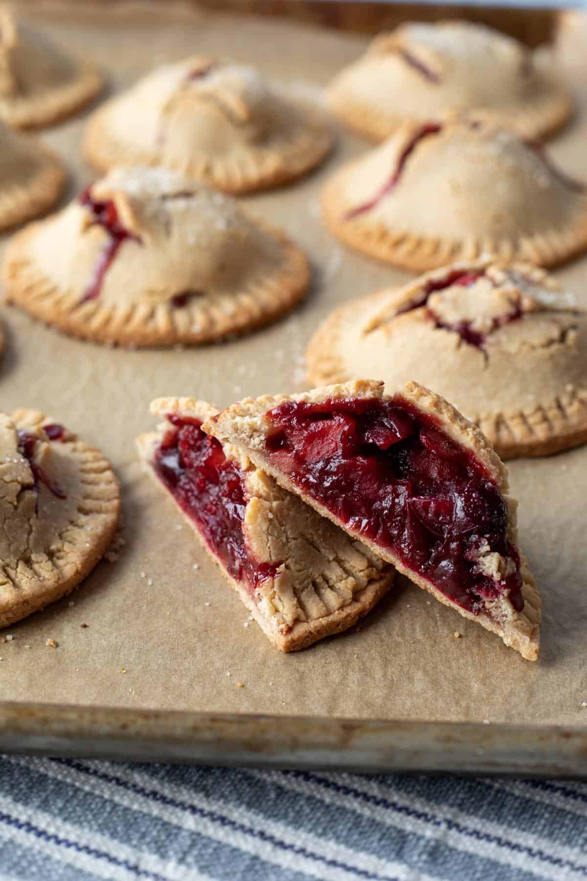 a cranberry hand pie cut in half to show filling inside.