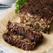 two slices of chickpea meatloaf with glaze resting on parchment paper.