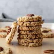a stack of crisp golden pecan cookies on a cookie sheet.