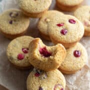 close up of a muffin with a bite taken out of one showing cranberry sauce inside.