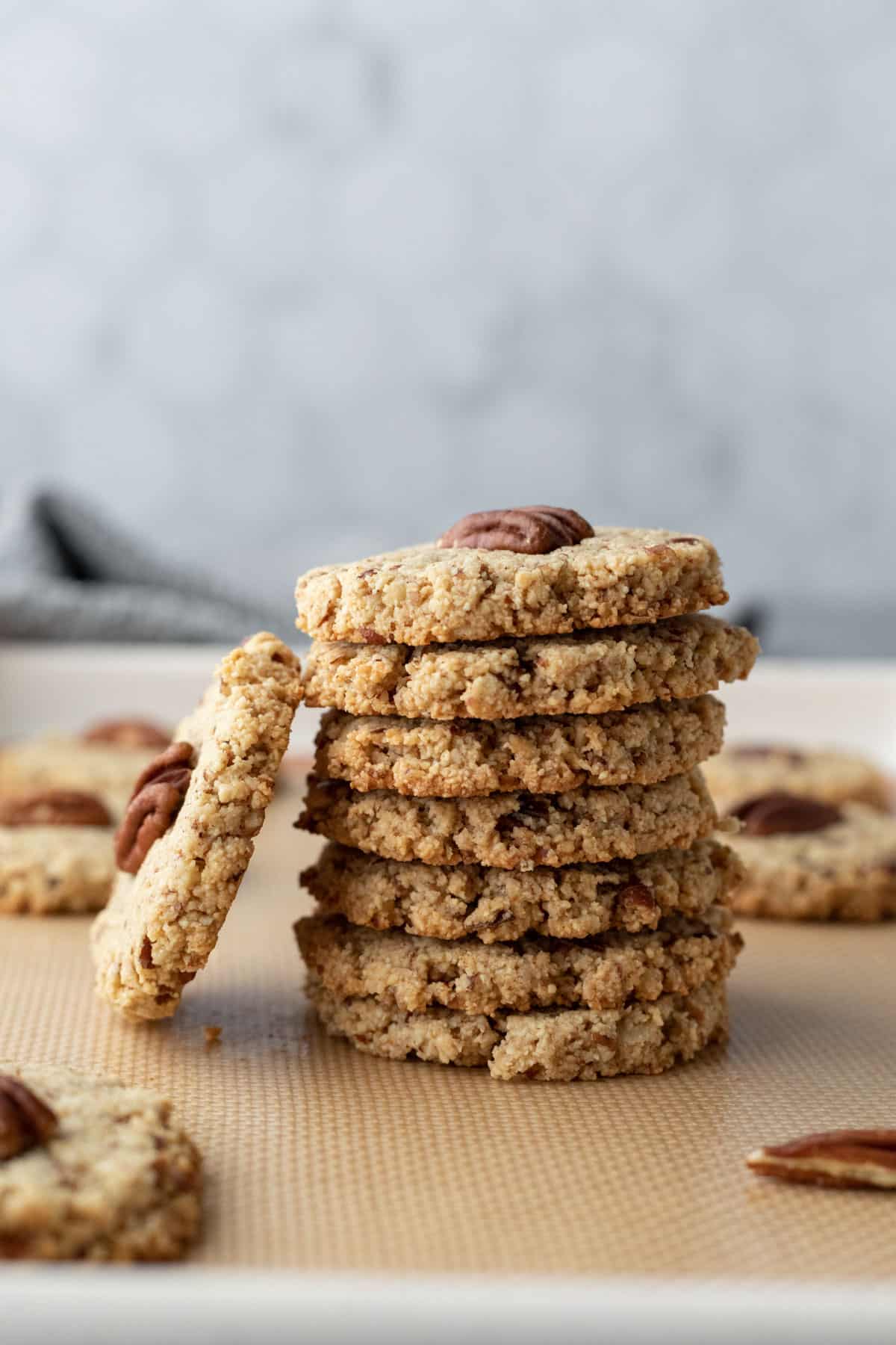 a tall stack of pecan flour cookies showing the nutty, rustic, and crisp textured edges.