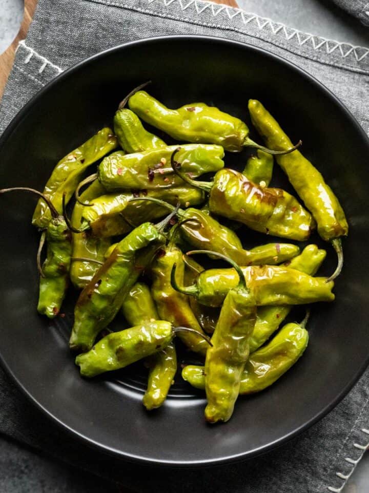 shishito peppers in a black bowl.