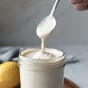 creamy salad dressing dripping from a spoon.
