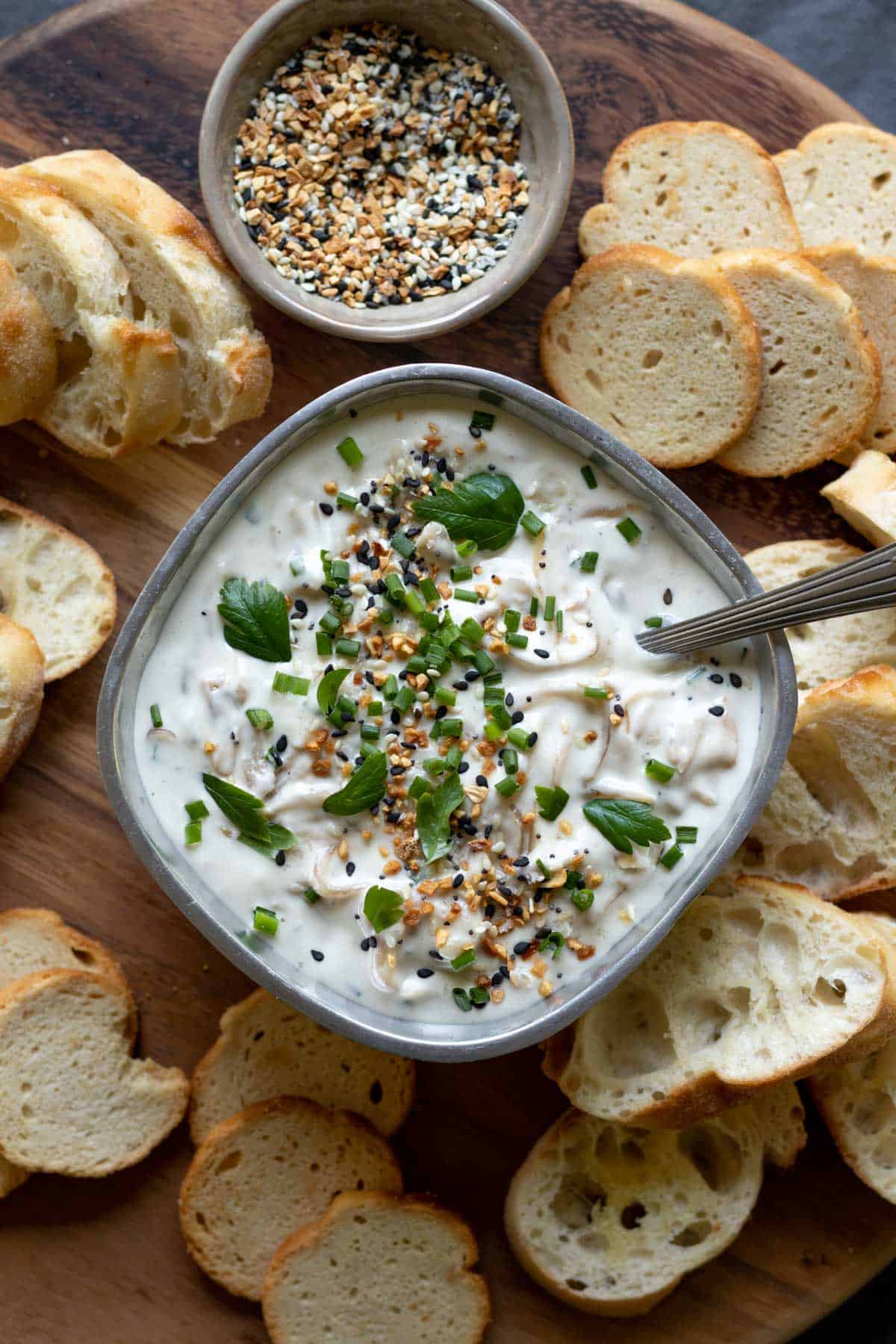 vegan onion dip in a small silver serving bowl garnished with parsley.