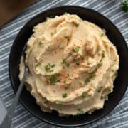 overhead view of Cajun cauliflower mashed potatoes in a black bowl.