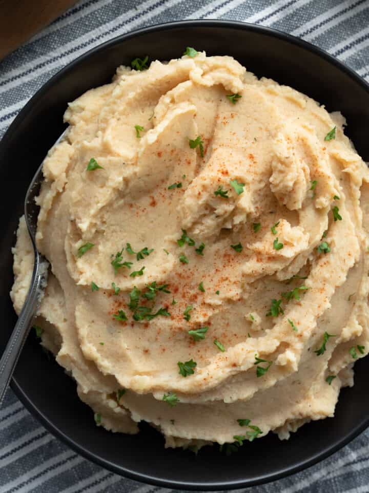 overhead view of Cajun cauliflower mashed potatoes in a black bowl.
