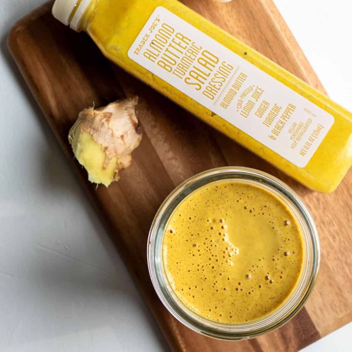 golden-colored salad dressing in a jar with a bottle of Trader Joe's dressing nearby.