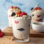 three glasses filled with creamy overnight oats topped with berries.