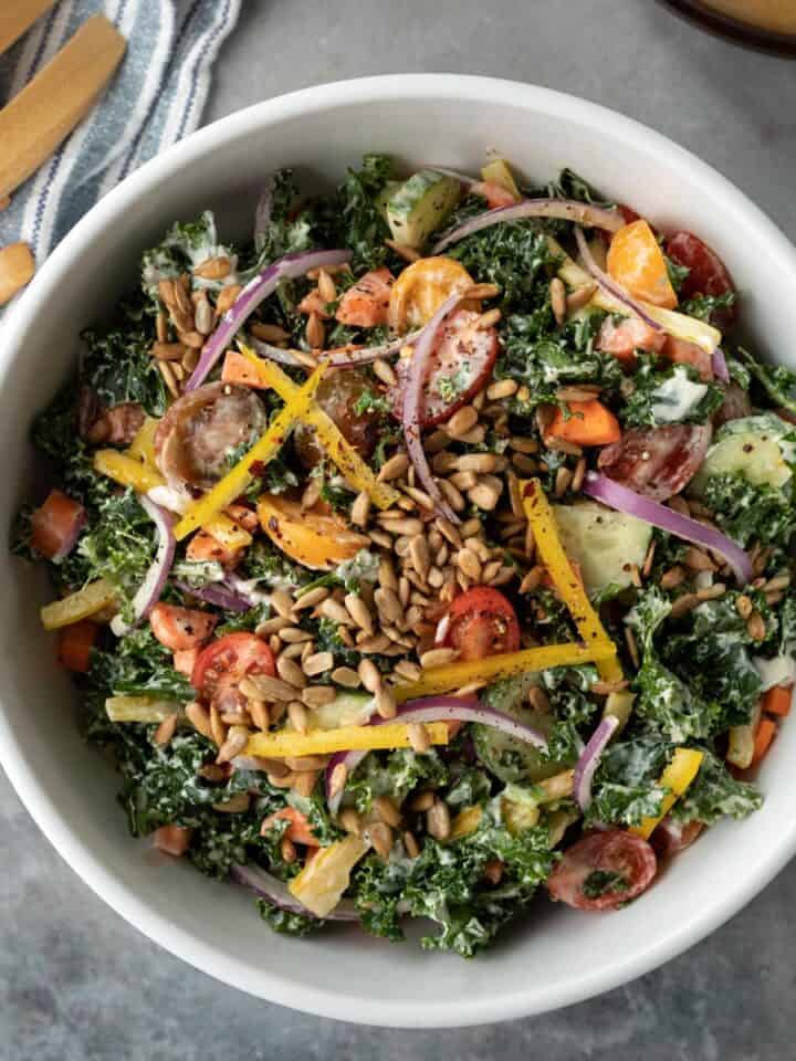 overhead photo of colorful vegan kale salad in a large bowl.