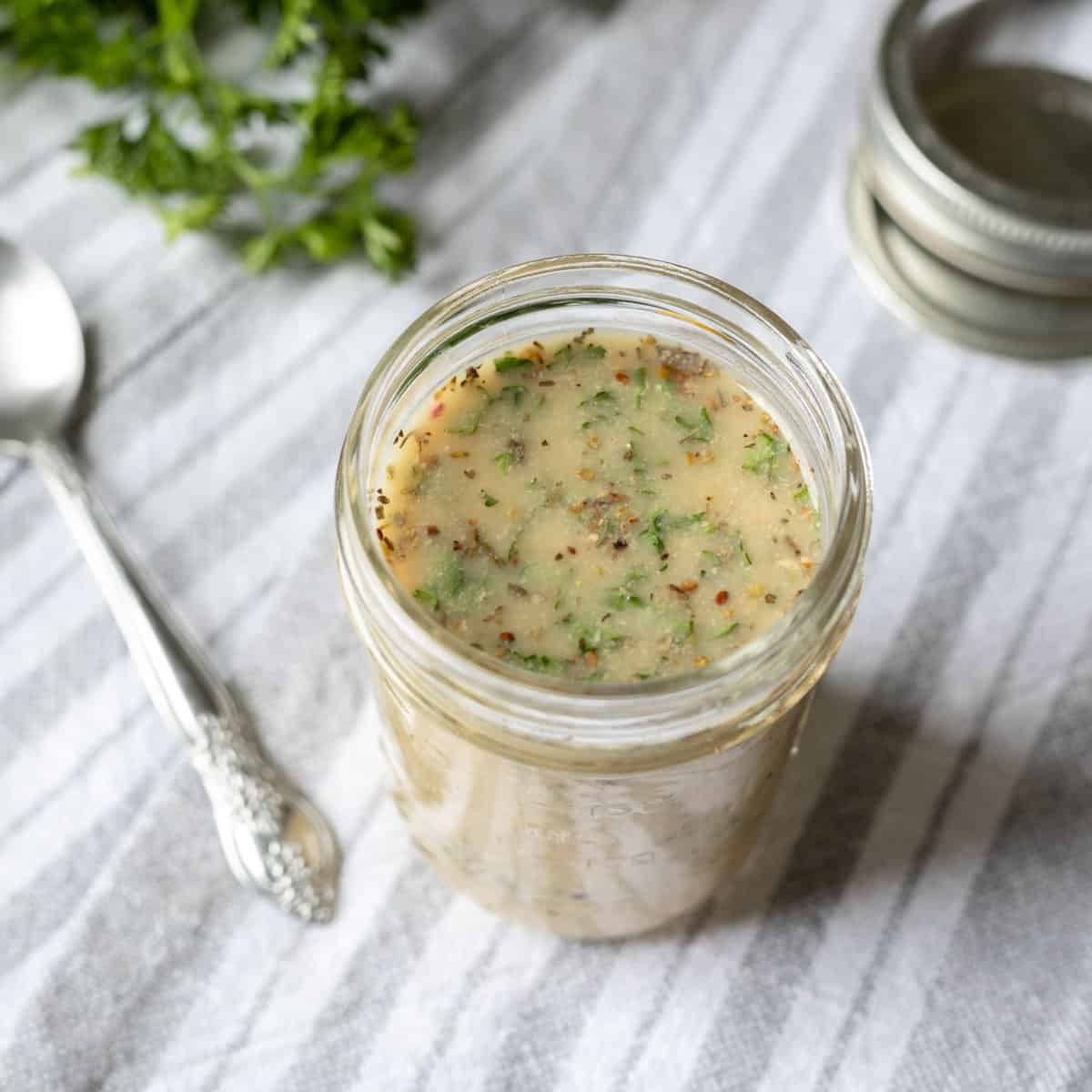 glass jar filled with a fat-free salad dressing made with herbs, lemon, and aquafaba.