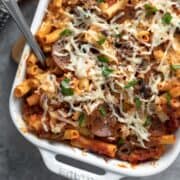 close up showing basil and melted vegan mozzarella on top of the pepperoni pasta bake.