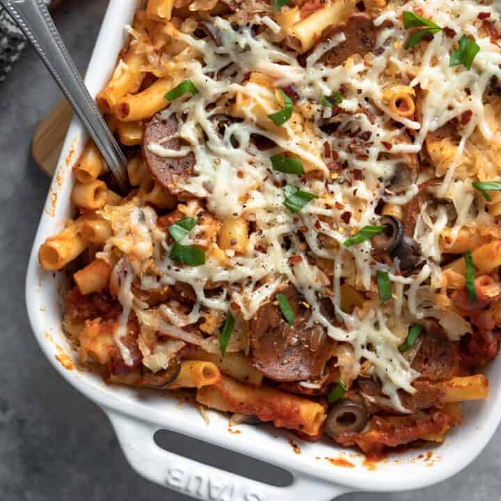 close up showing basil and melted vegan mozzarella on top of the pepperoni pasta bake.