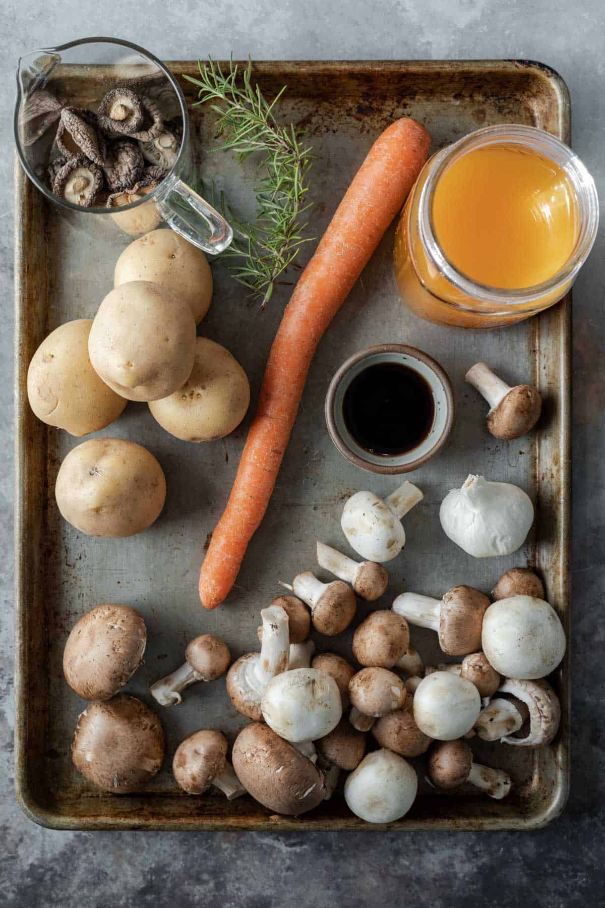 ingredients for mushroom stew laid out on a large baking sheet.